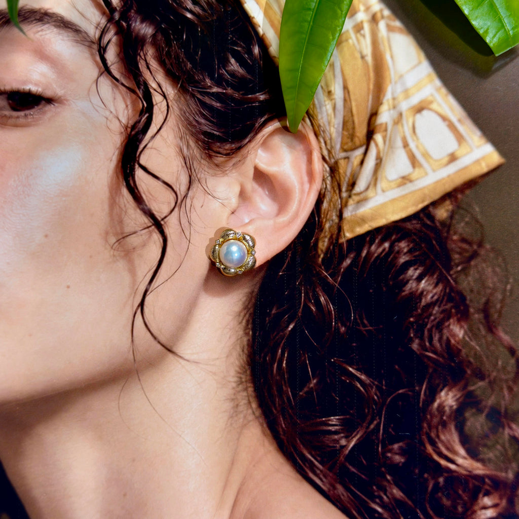 Blue and pink iridescent white pearl earrings on model.