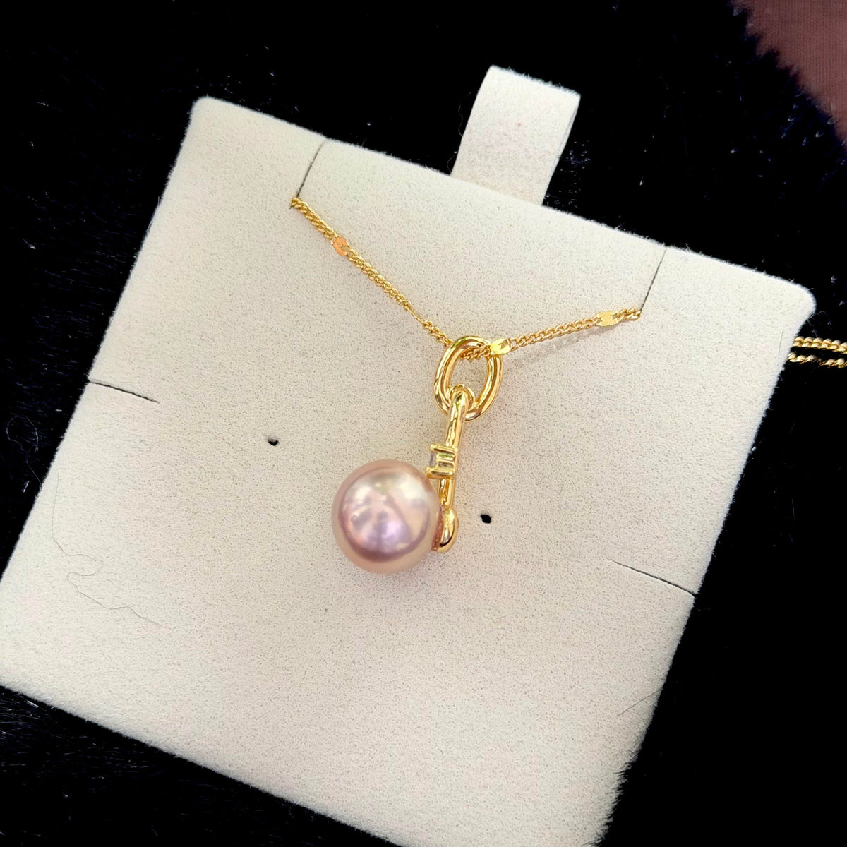 Golden-pink pearl necklace styled for elegant evening wear.