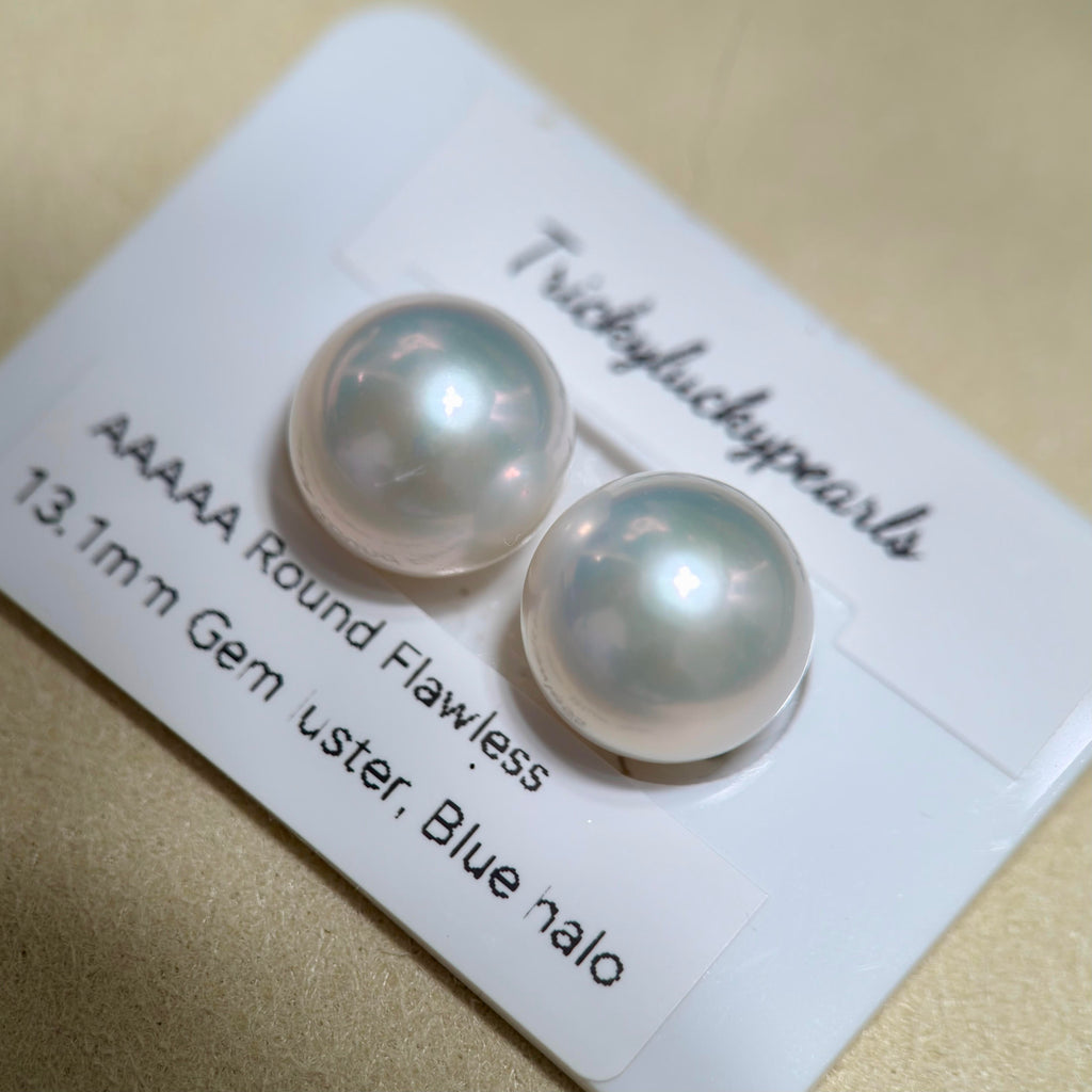 Cold blue halo white pearl studs with bright iridescent glow.