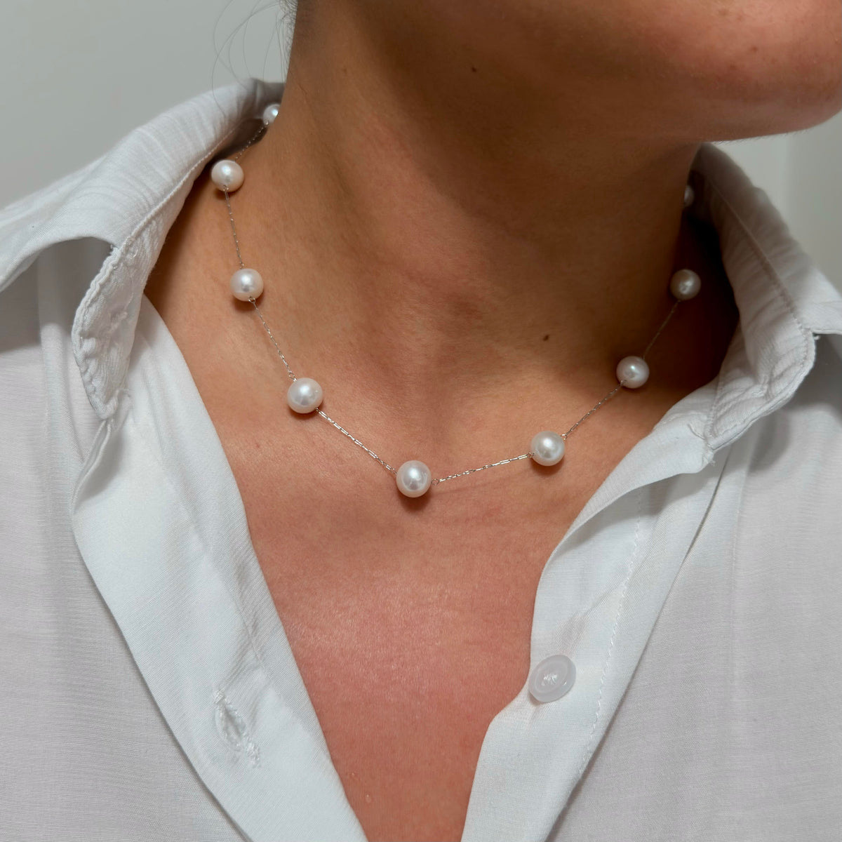 Close-up of a floating pearl station necklace with evenly spaced freshwater pearls.