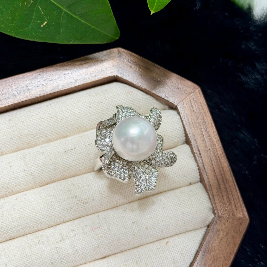 Sparkling flower ring centred with a luminous white pearl.