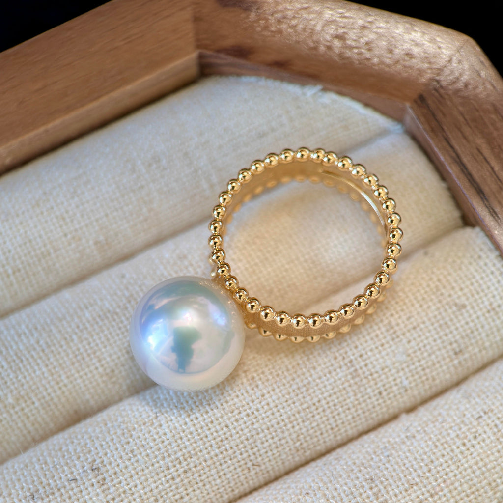 White freshwater pearl displaying blue and pink iridescent light.