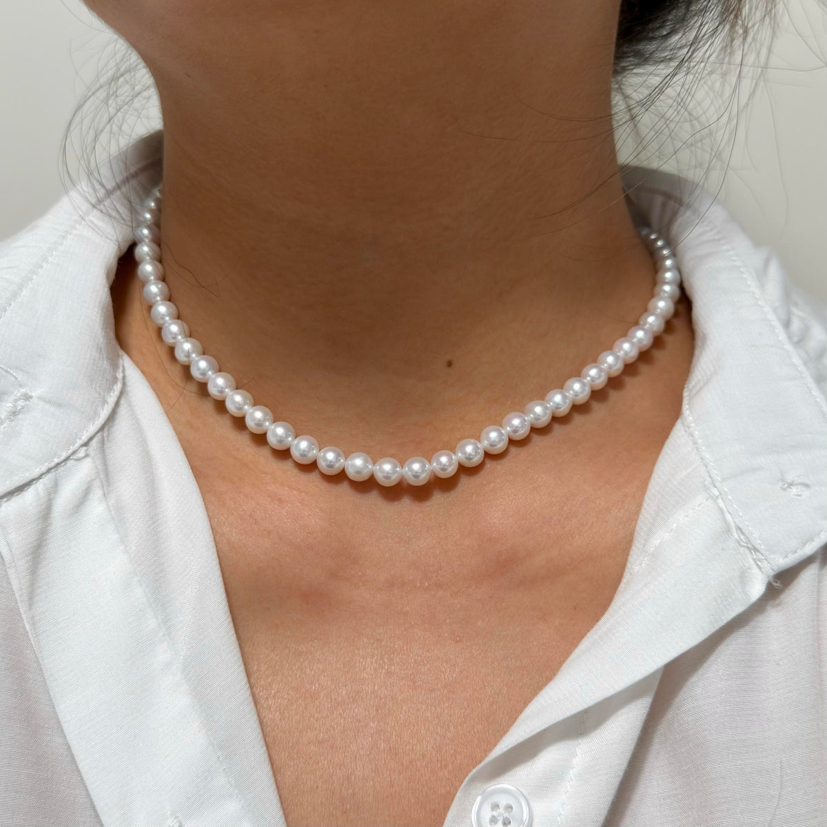 Full strand view of 6–7 mm cool white with blue-silver iridescence freshwater pearl necklace, 41 cm long.