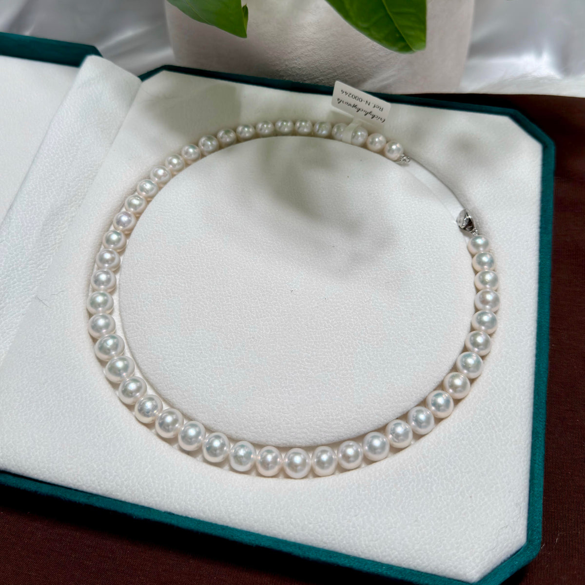 Close-up of 10 mm cool white with silver-blue halo freshwater pearl necklace, 42 cm long.