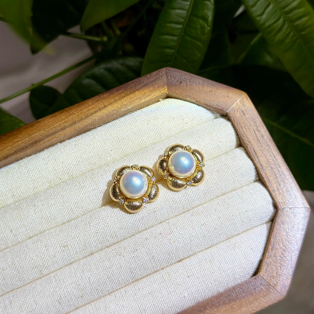 Vintage-inspired pearl earrings with sculpted floral details.