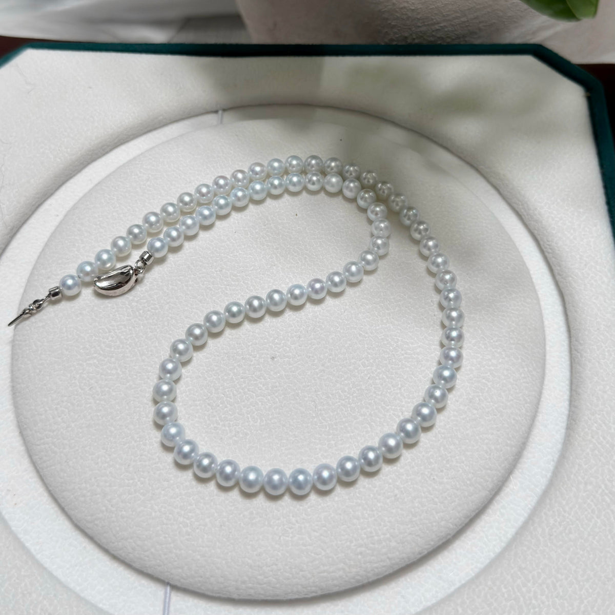 Freshwater pearl necklace showing how the icy-blue overtone shifts in different light.