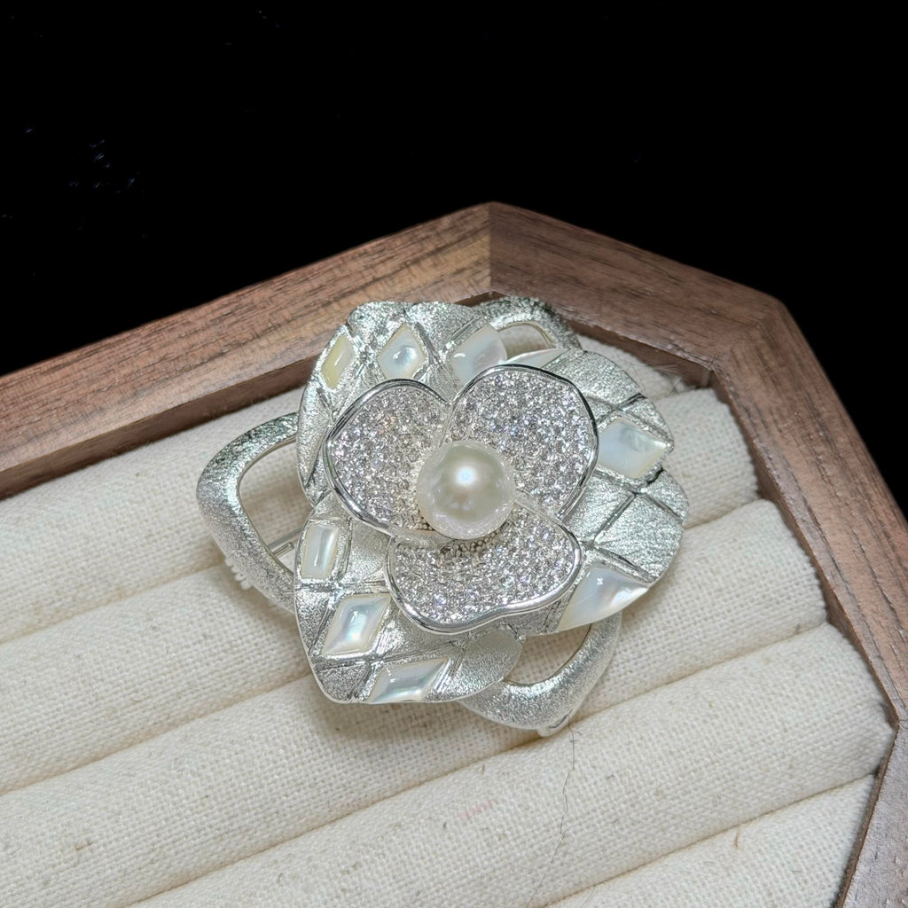 Classic floral brooch featuring a luminous white freshwater pearl centerpiece.