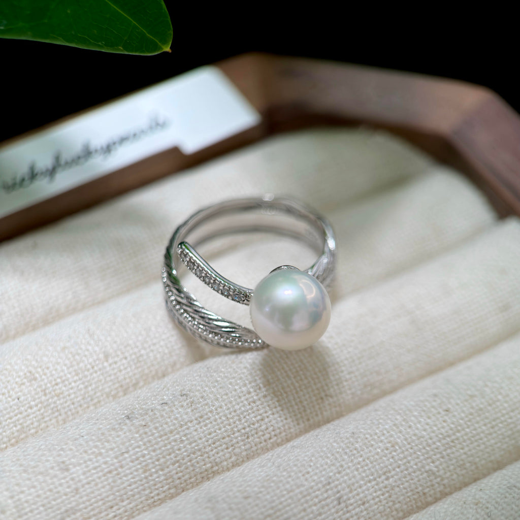Nature-inspired pearl ring featuring a sculpted silver feather.