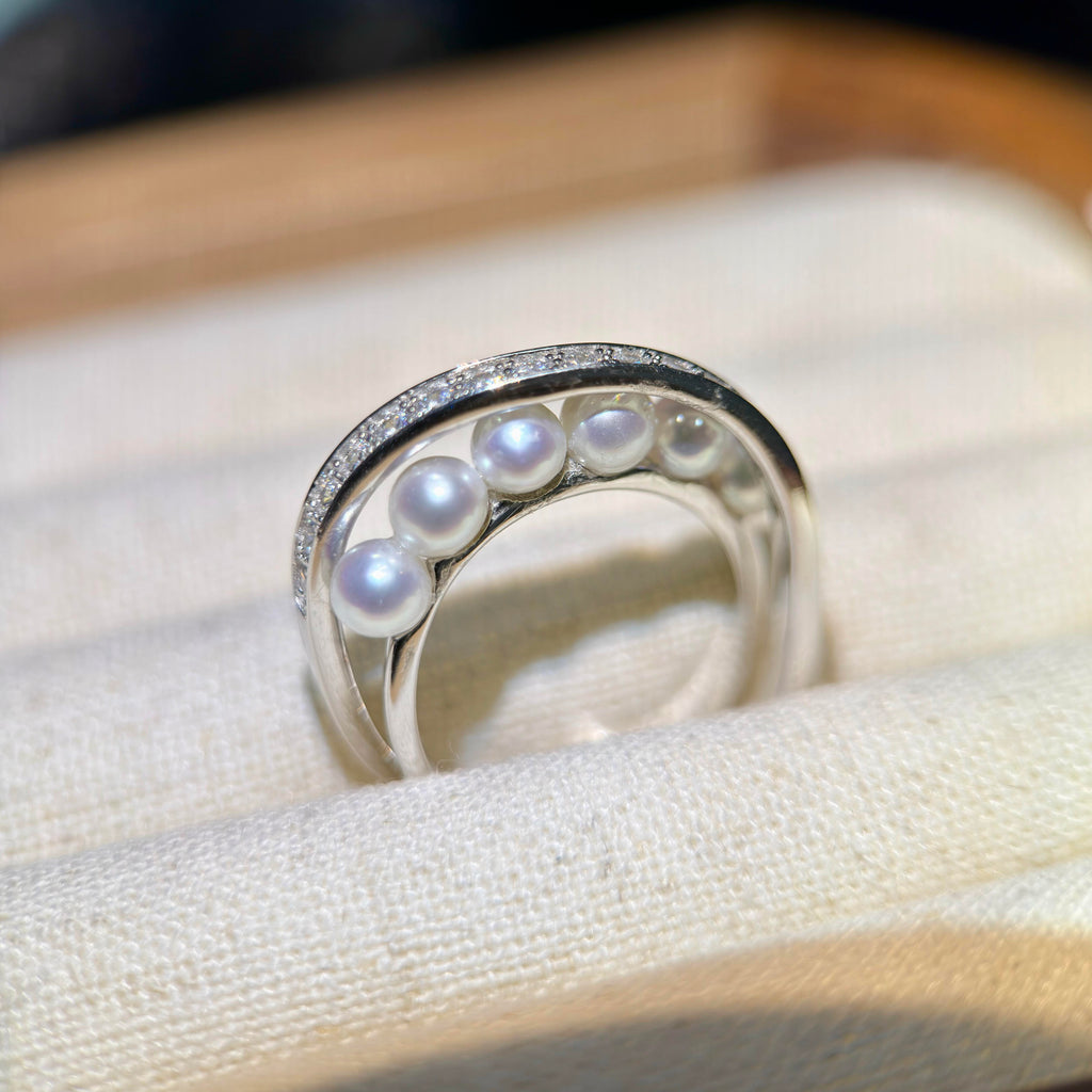 White freshwater pearl ring with a modern celestial design.