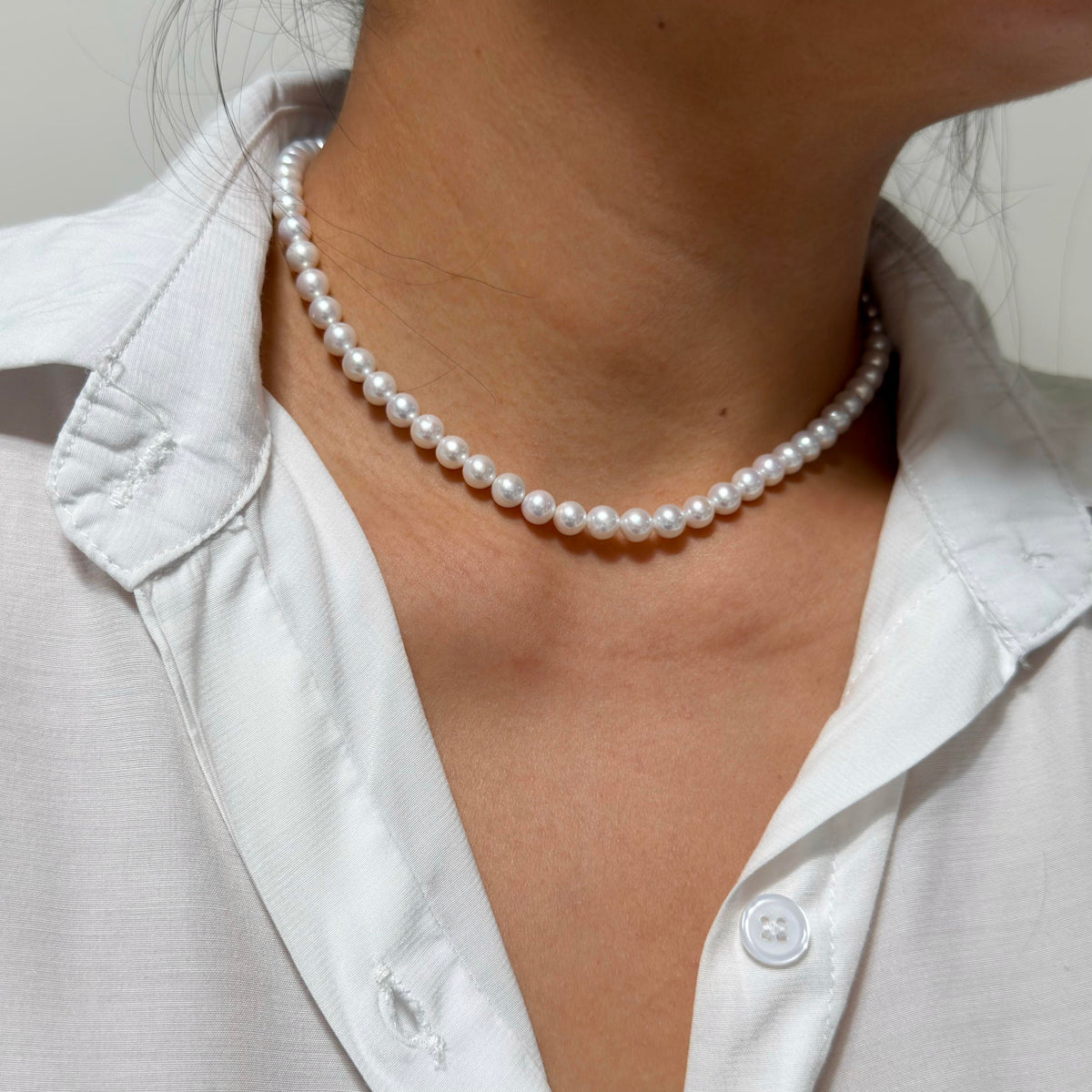 Full strand view of 6–7 mm cool white with blue-silver iridescence freshwater pearl necklace, 41 cm long.