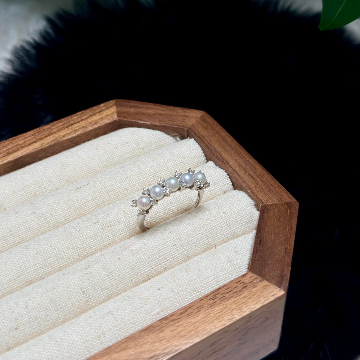 Dainty white pearl ring with soft blue and pink iridescence.