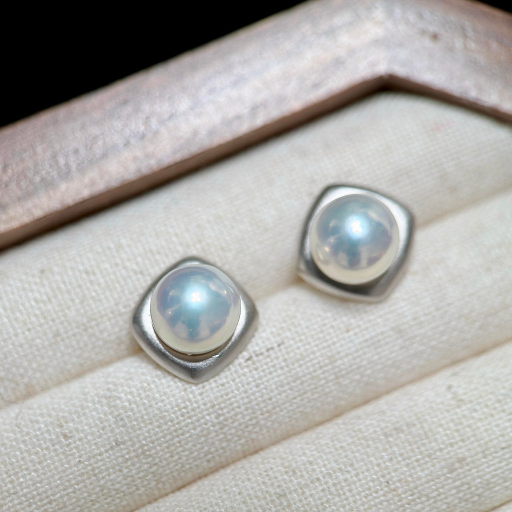 Minimalist pearl studs styled as elegant everyday jewelry.
