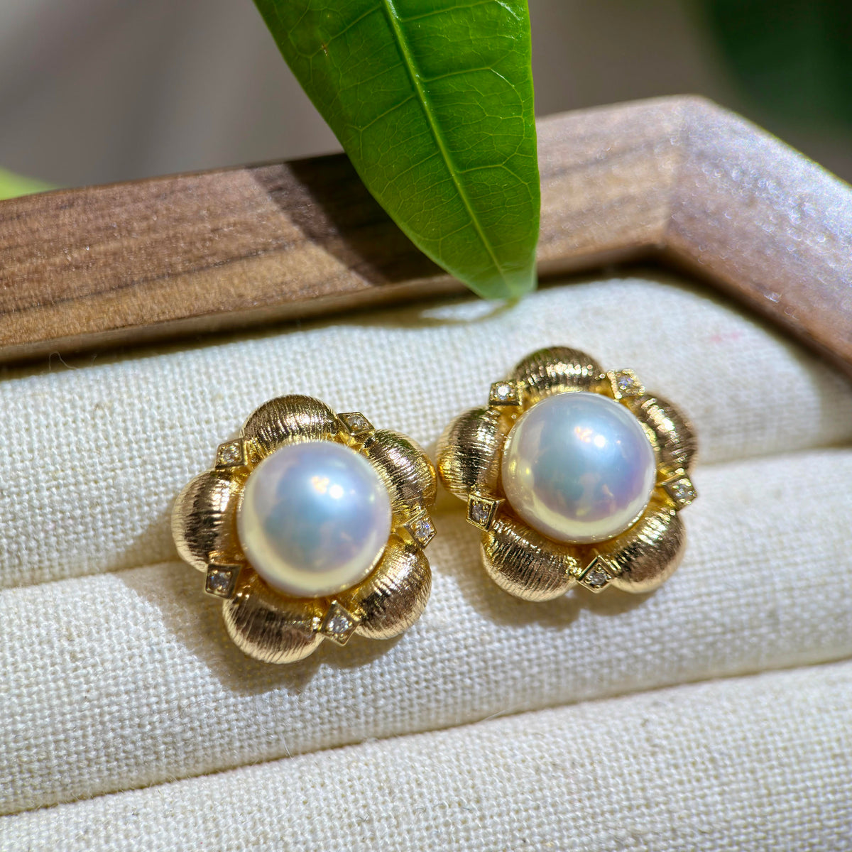 Blue-pink halo white pearls set in gold floral earrings.