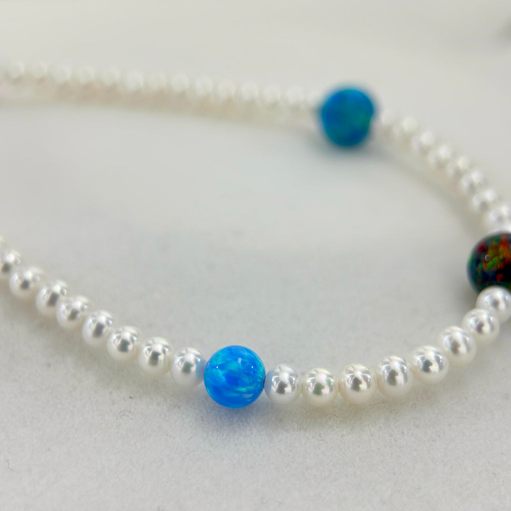 Blue-green opal accents spaced between luminous white freshwater pearls.

