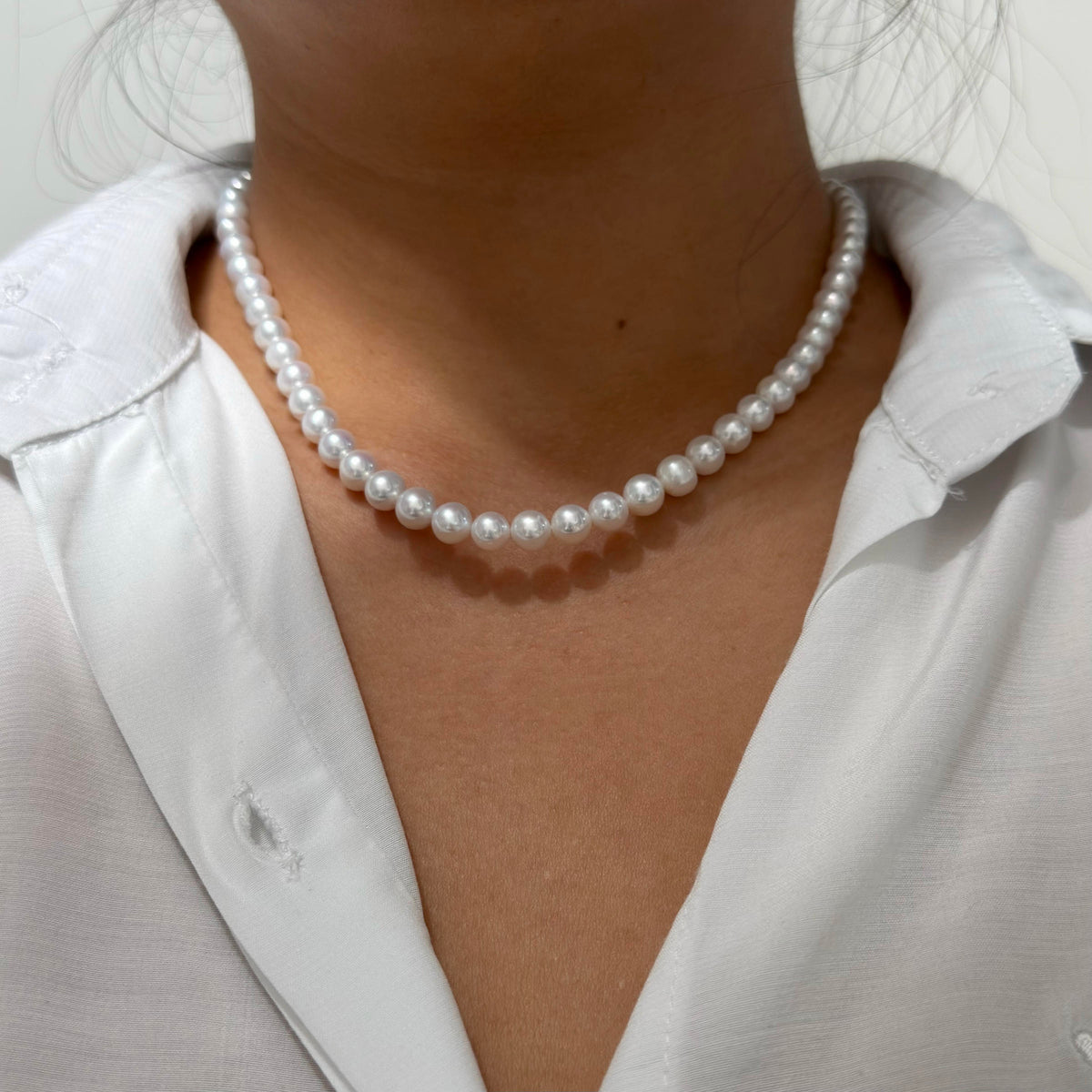 Close-up of 7 mm cool white with vivid blue iridescence freshwater pearl necklace, 42 cm long.
