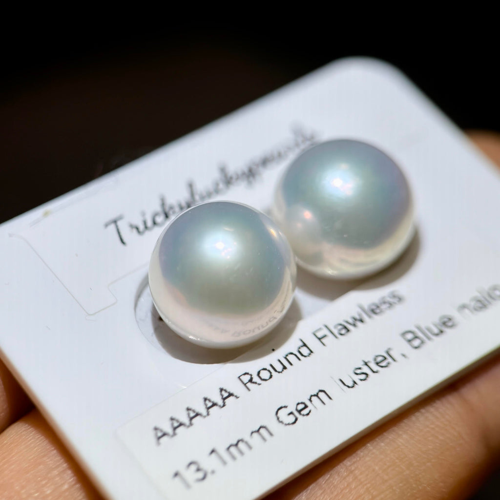 13.1 mm white freshwater pearl stud earrings with vivid blue halo.