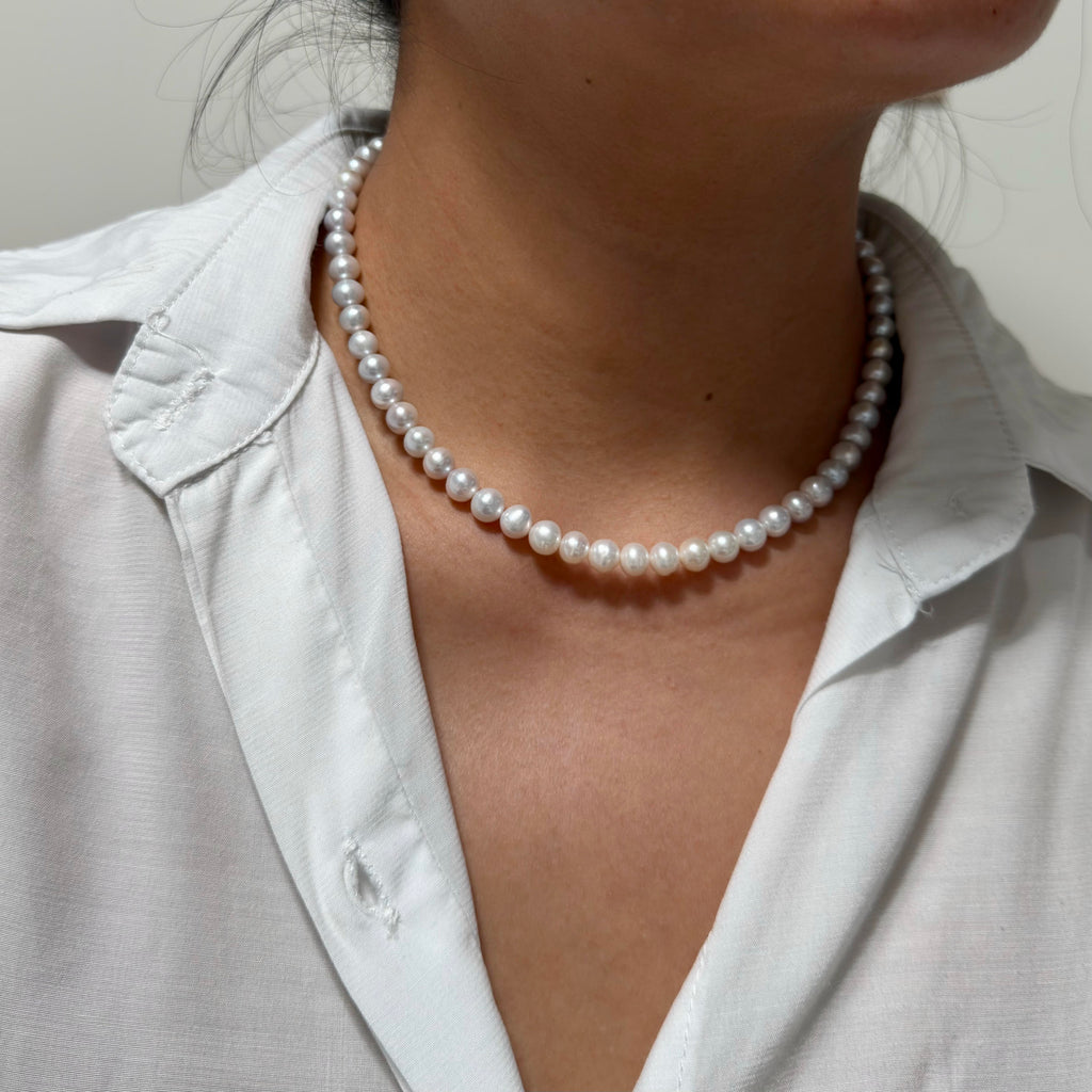 Grey and white freshwater pearl necklace displaying a soft blue halo.