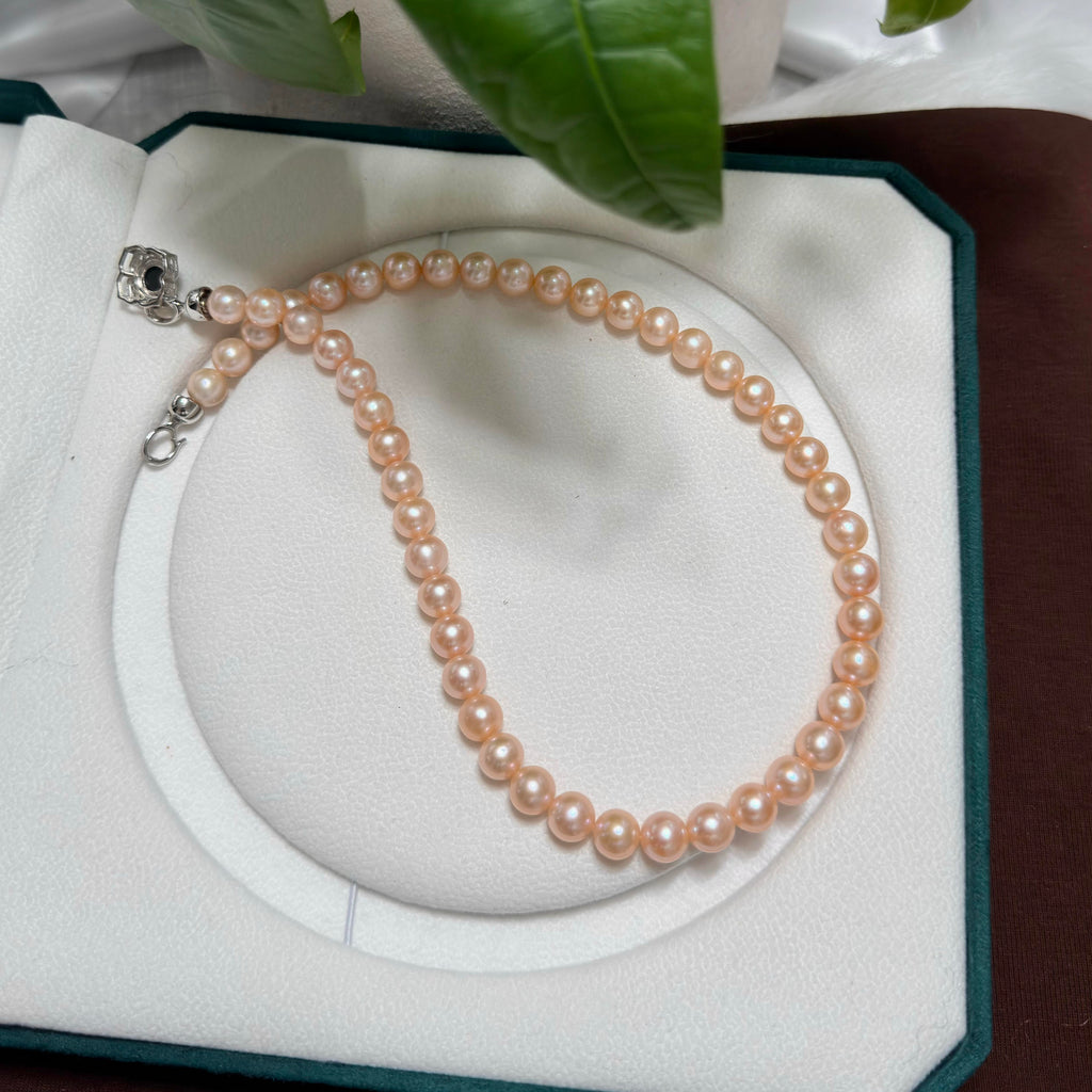 Classic single-strand necklace made with light-orange freshwater pearls.
