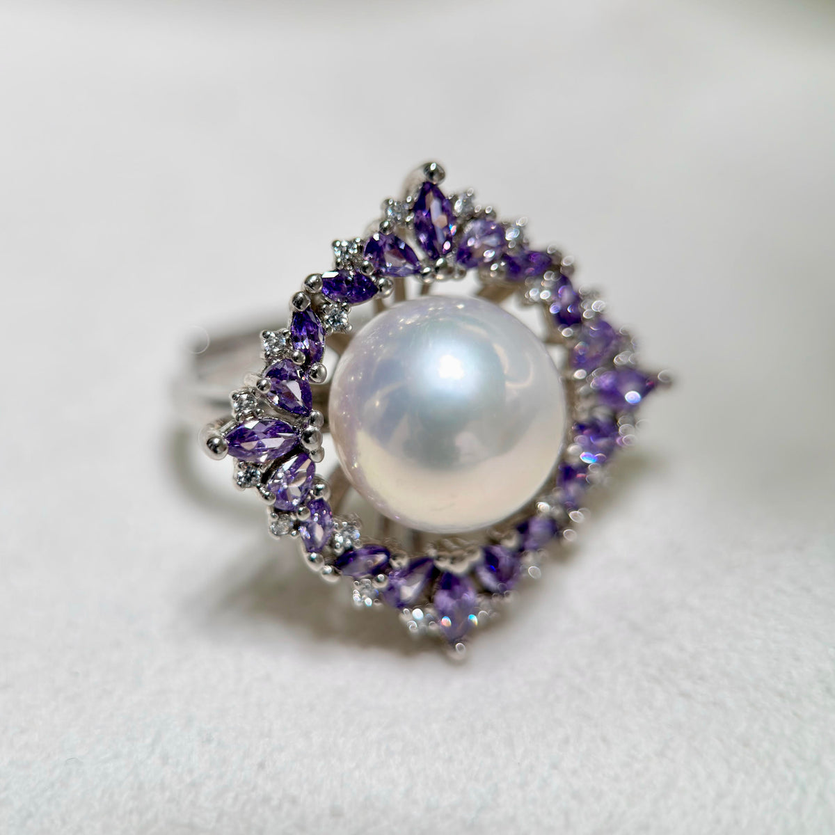 Purple zirconia flower ring with luminous natural freshwater pearl.