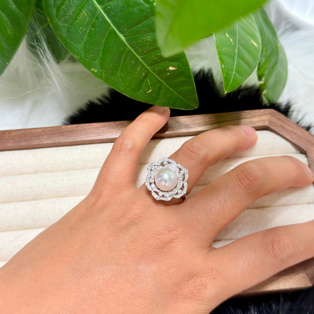 Sterling silver camellia pearl ring shown worn on the hand.