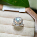 White pearl ring with sparkling mixed-cut zirconia halo.