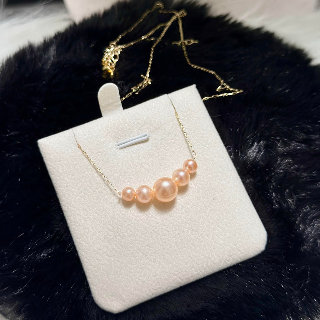 Modern golden-orange pearl necklace with minimalist styling.