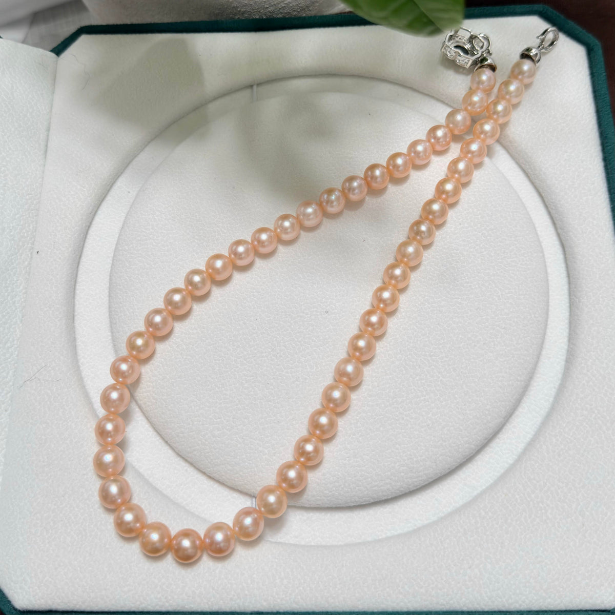 Peach-orange natural pearl strand with warm luminous colour.
