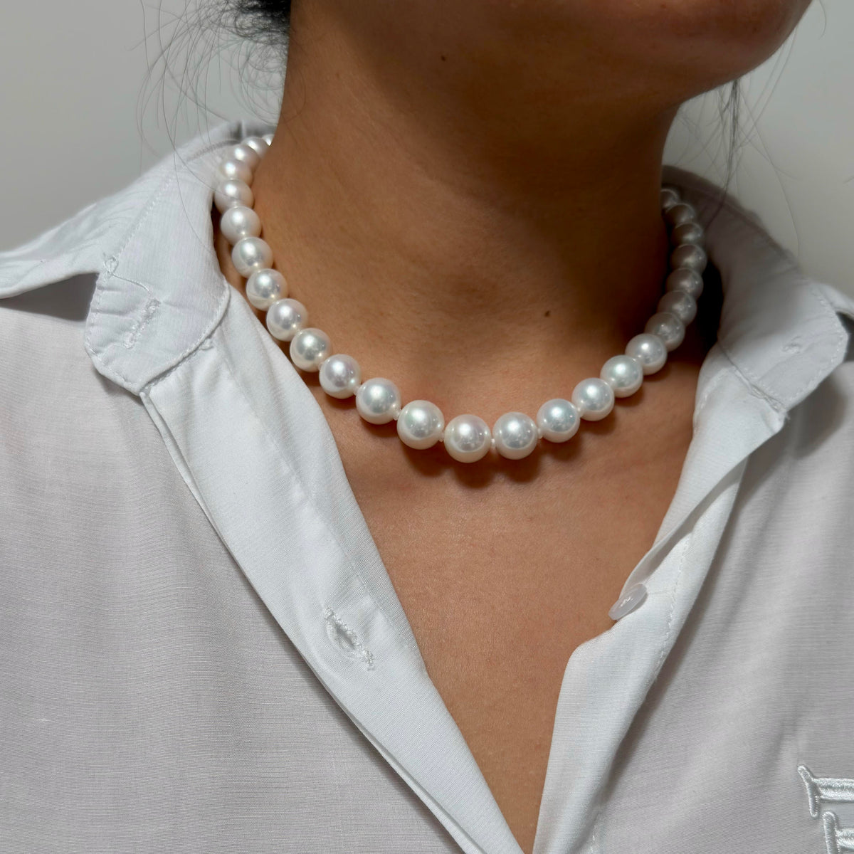 Full strand view of 11–13 mm white with blue-pink aurora halo freshwater pearl necklace, 45 cm long.
