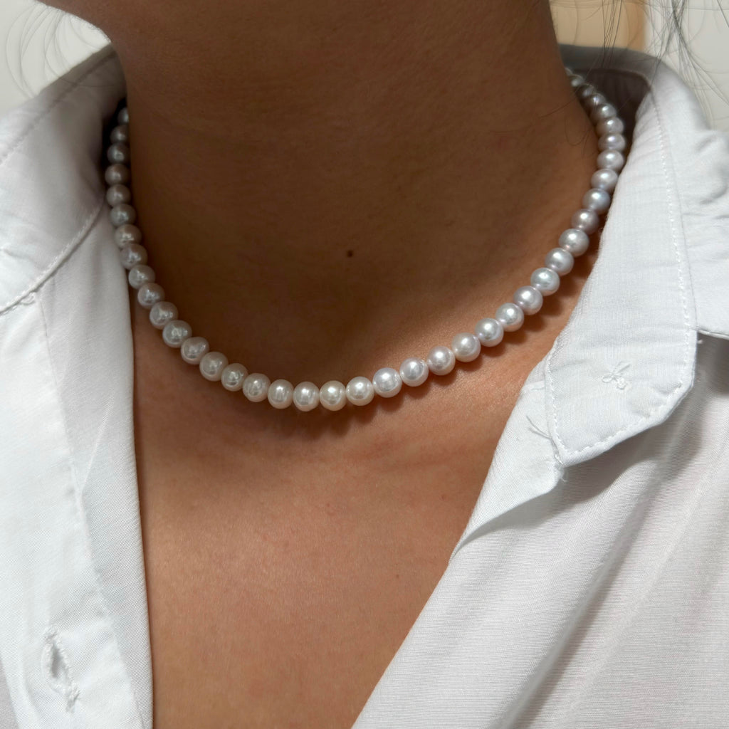 Modern minimalist necklace featuring 7 mm grey-to-white freshwater pearls.