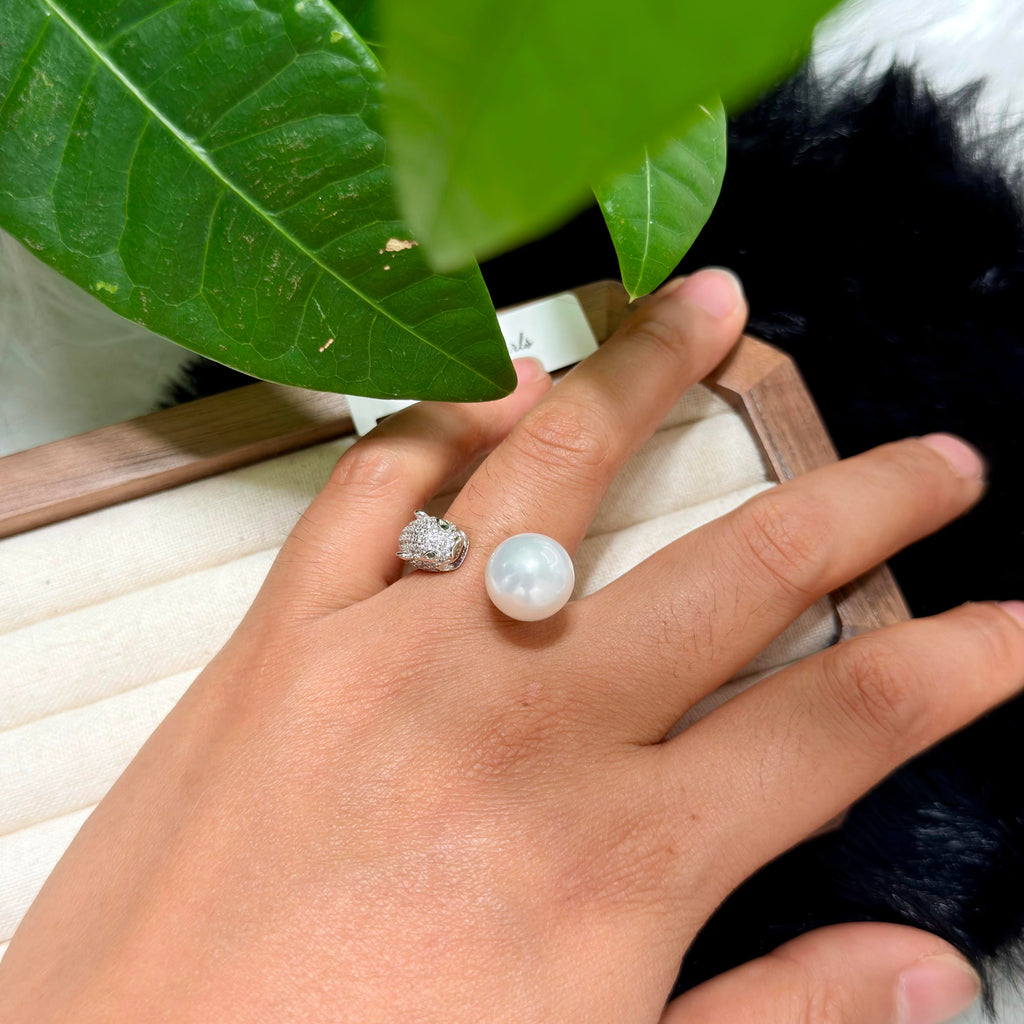 Adjustable white pearl ring with panther head detail.