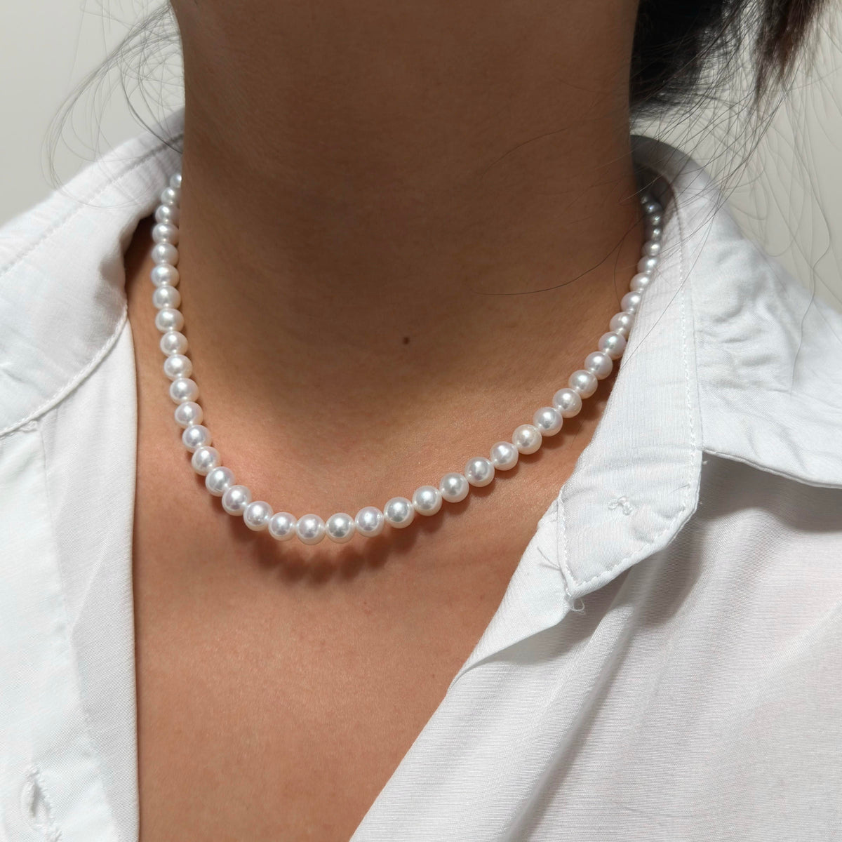 Full strand view of 7 mm cool white with vivid blue iridescence freshwater pearl necklace, 42 cm long.

