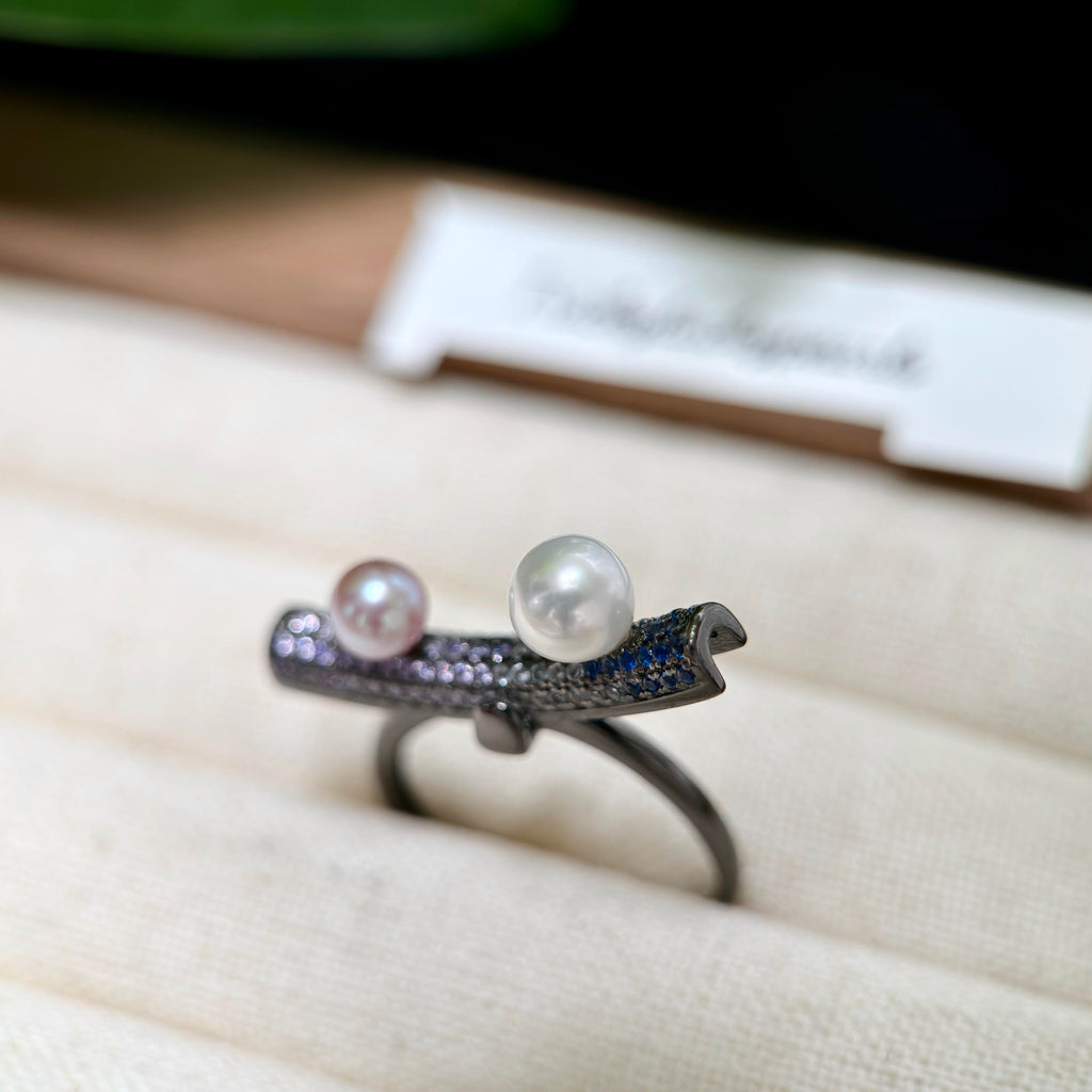 Movable balance-beam pearl ring with sparkling stone accents.