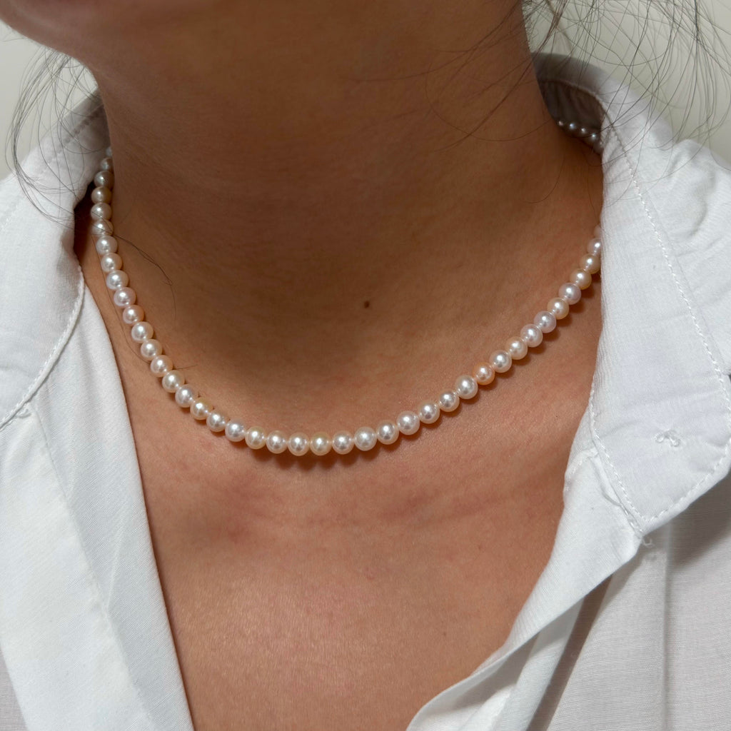 Close-up of 5–6 mm mixed white and soft golden tones freshwater pearl necklace, 41 cm long.