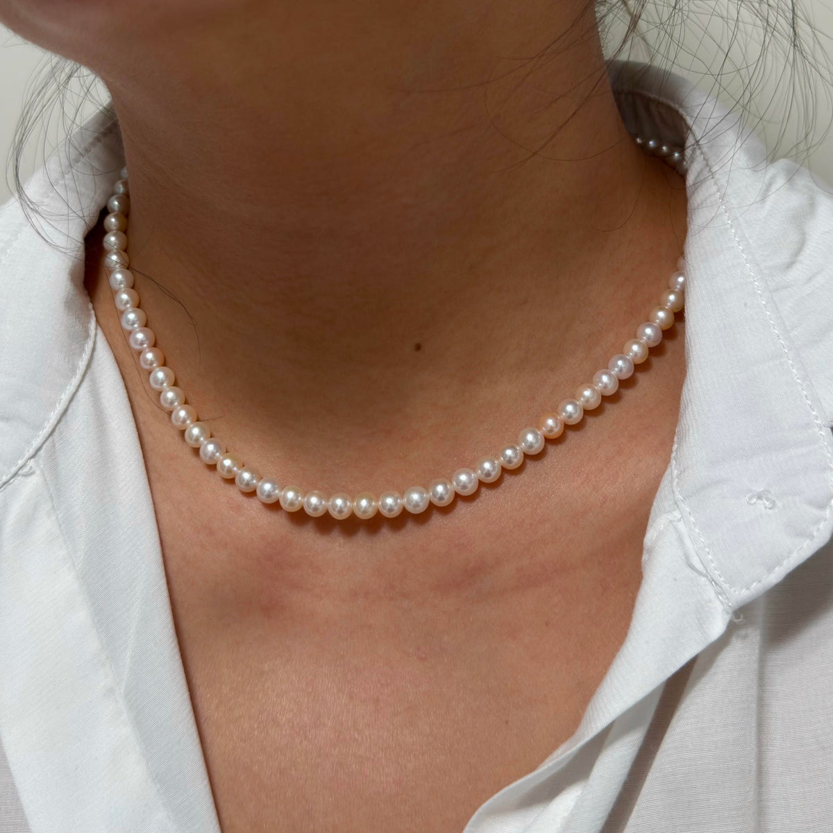 Close-up of 5–6 mm mixed white and soft golden tones freshwater pearl necklace, 41 cm long.