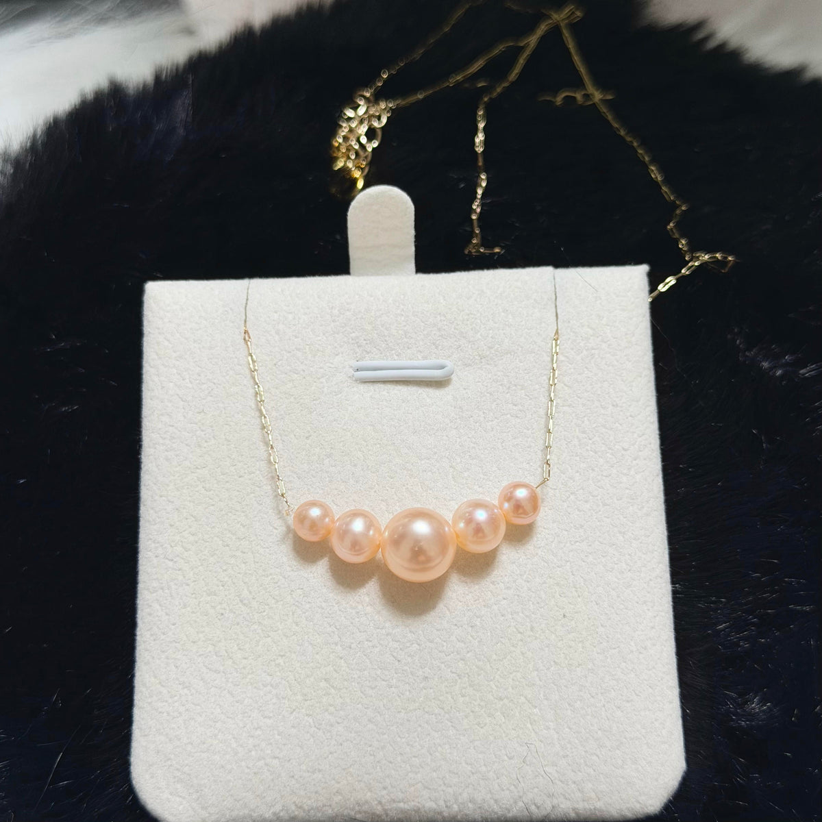 Iridescent orange pearl necklace styled for elegant evening wear.