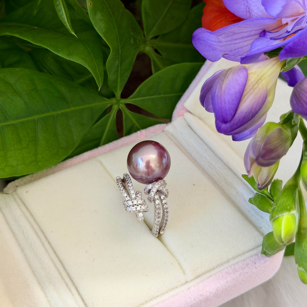 Deep purple bow ring featuring a mirror-luster freshwater pearl.
