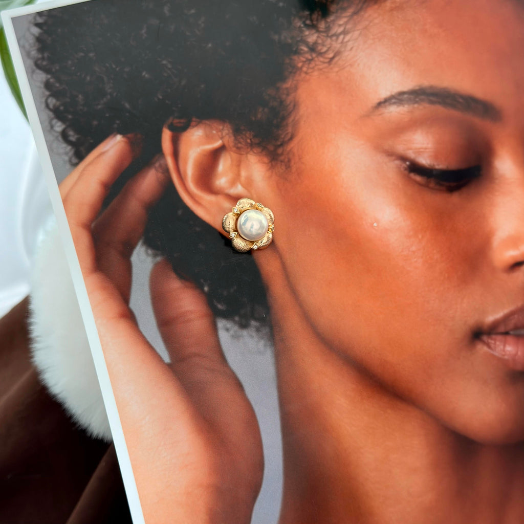 Gold flower earrings centered with luminous freshwater pearls.
