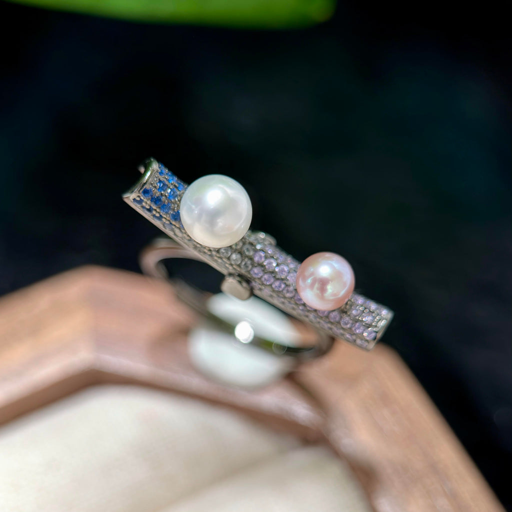 White and purple-blue freshwater pearls on a modern silver ring.