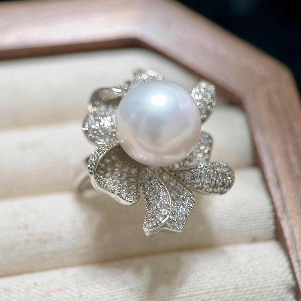 Large white pearl ring with sparkling floral silver-plated setting.