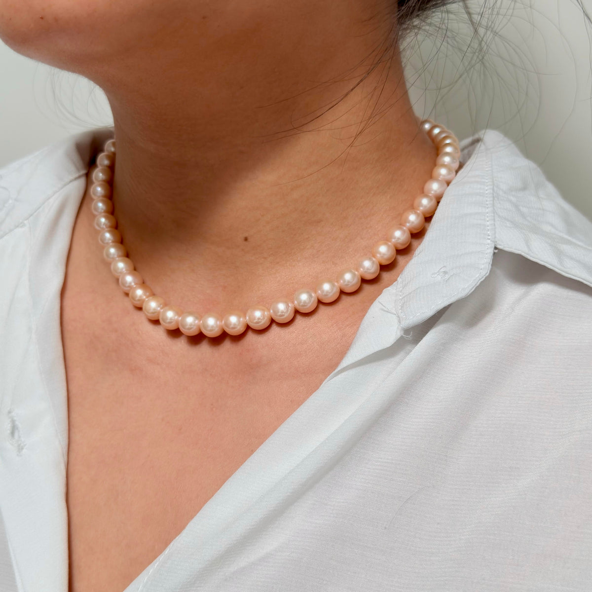 Elegant light-orange pearl necklace with a timeless single-strand design.
