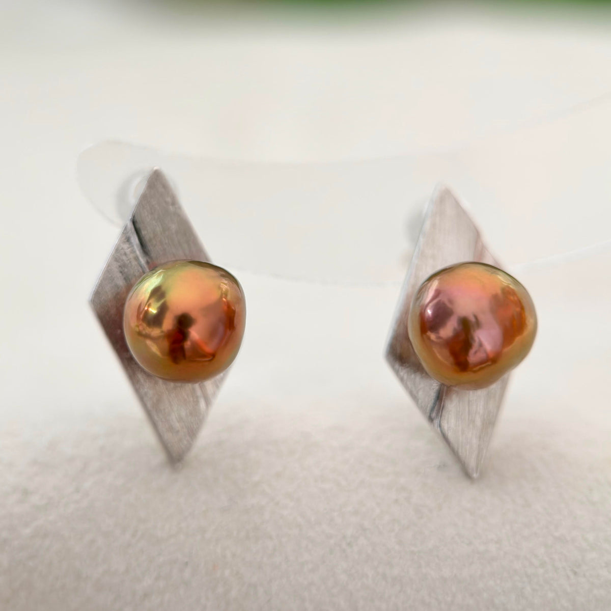 Reddish-brown baroque pearl earrings with subtle green overtones and brushed silver setting.
