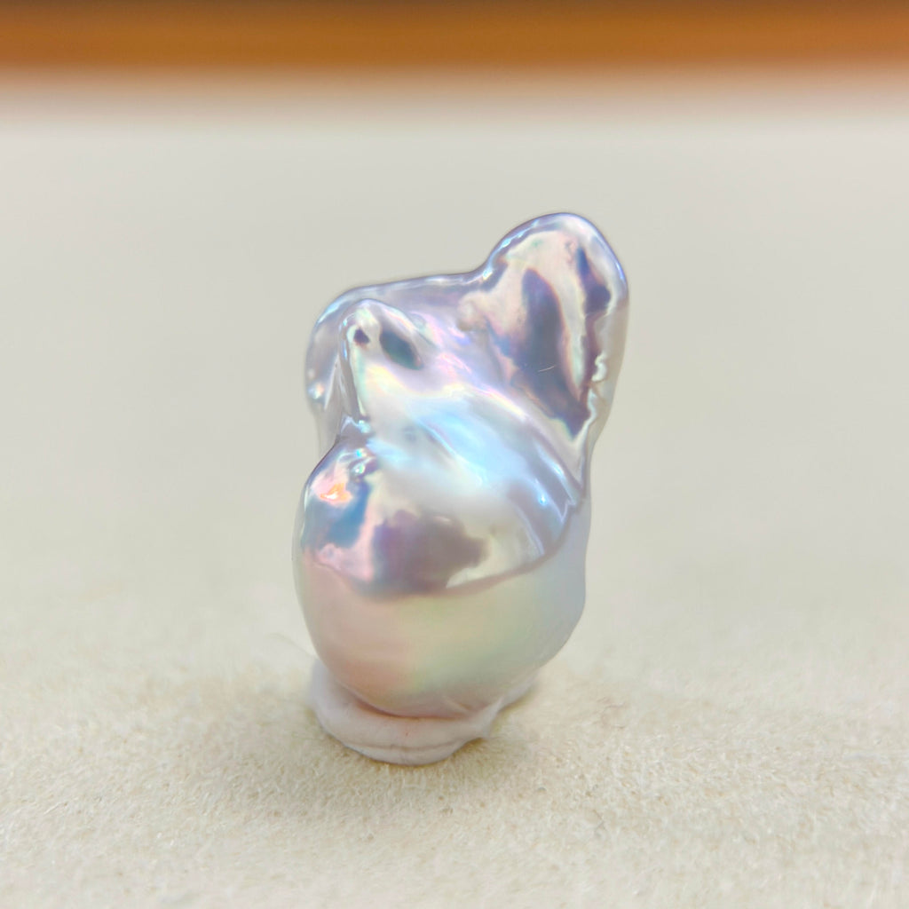 Mint green pearl pendant with blue iridescence and warm red halo accents.