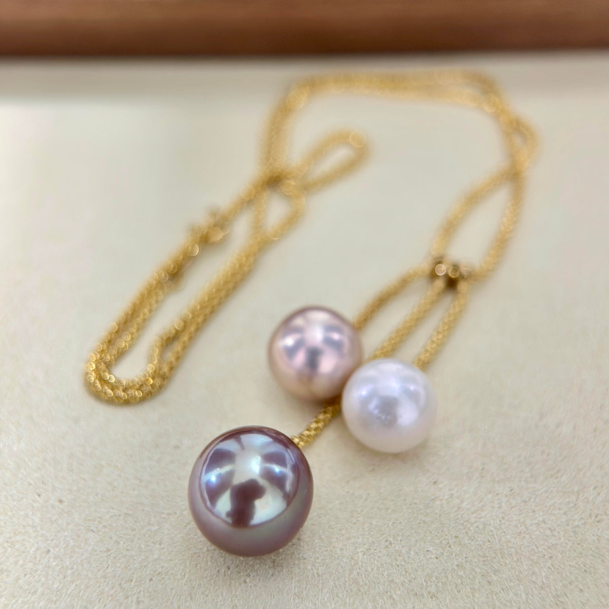 Multicolor three-pearl necklace styled as modern statement jewelry.