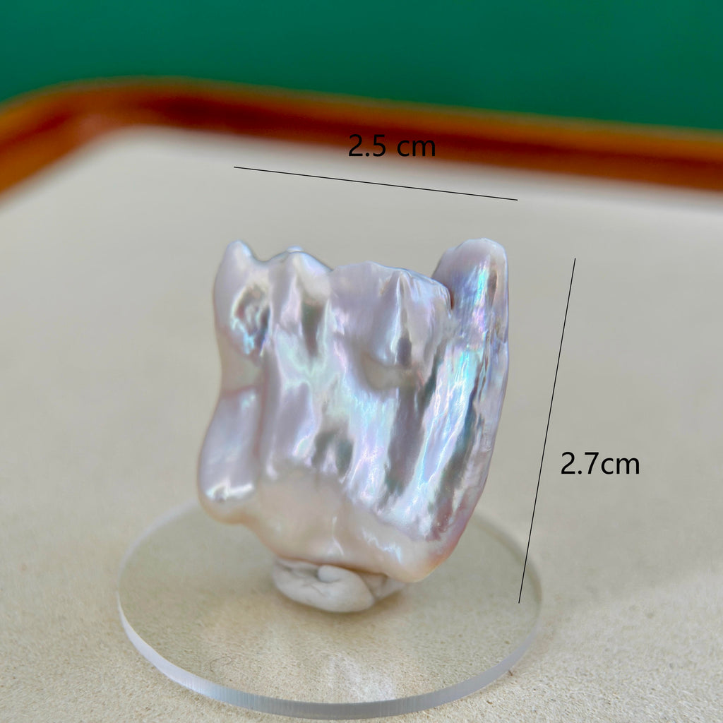 A baroque freshwater pearl with an iridescent luster, displayed on a clear acrylic stand. Black measurement lines and text overlay indicate its dimensions are 2.