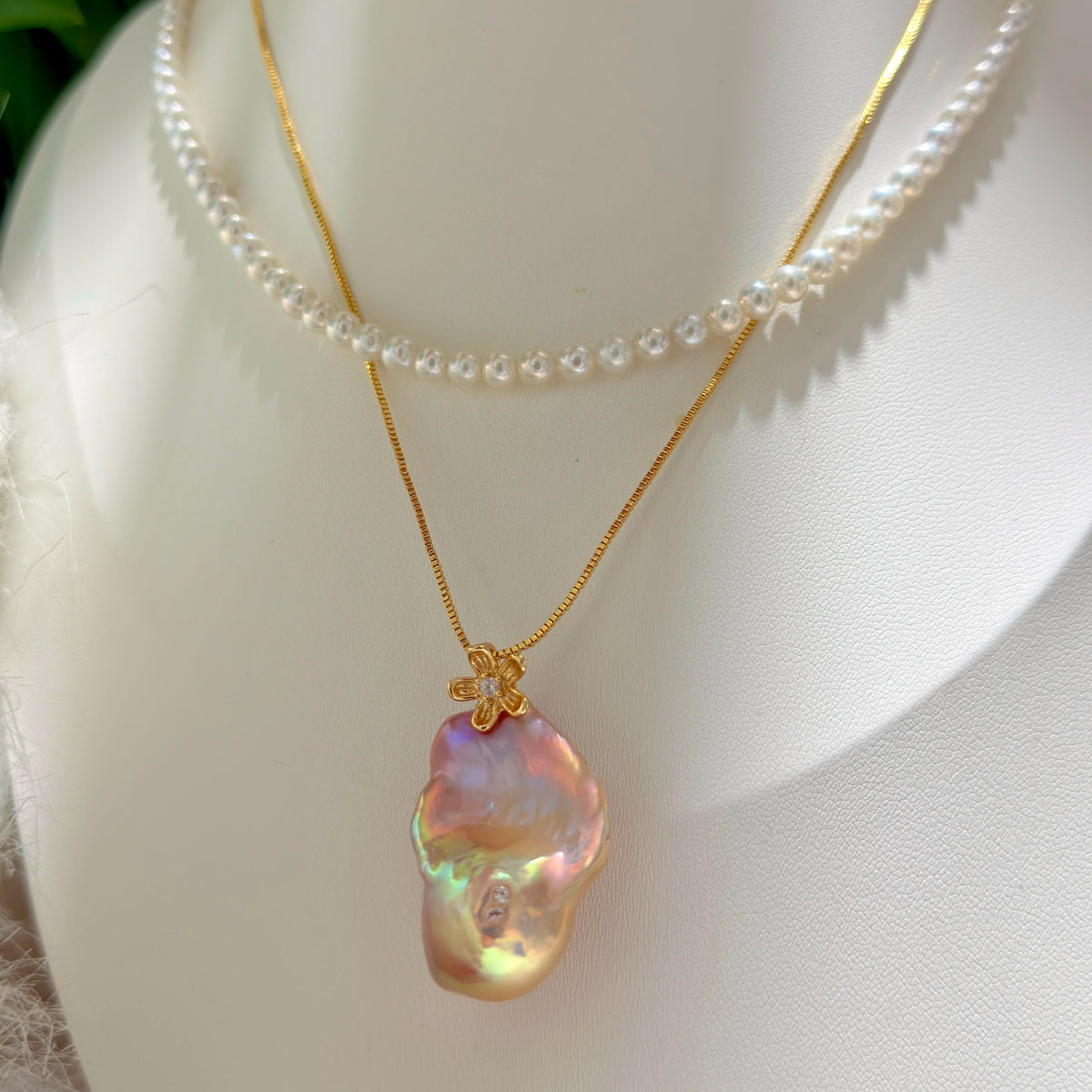 Golden-green baroque freshwater pearl pendant with sculptural osmanthus flower in sterling silver.

