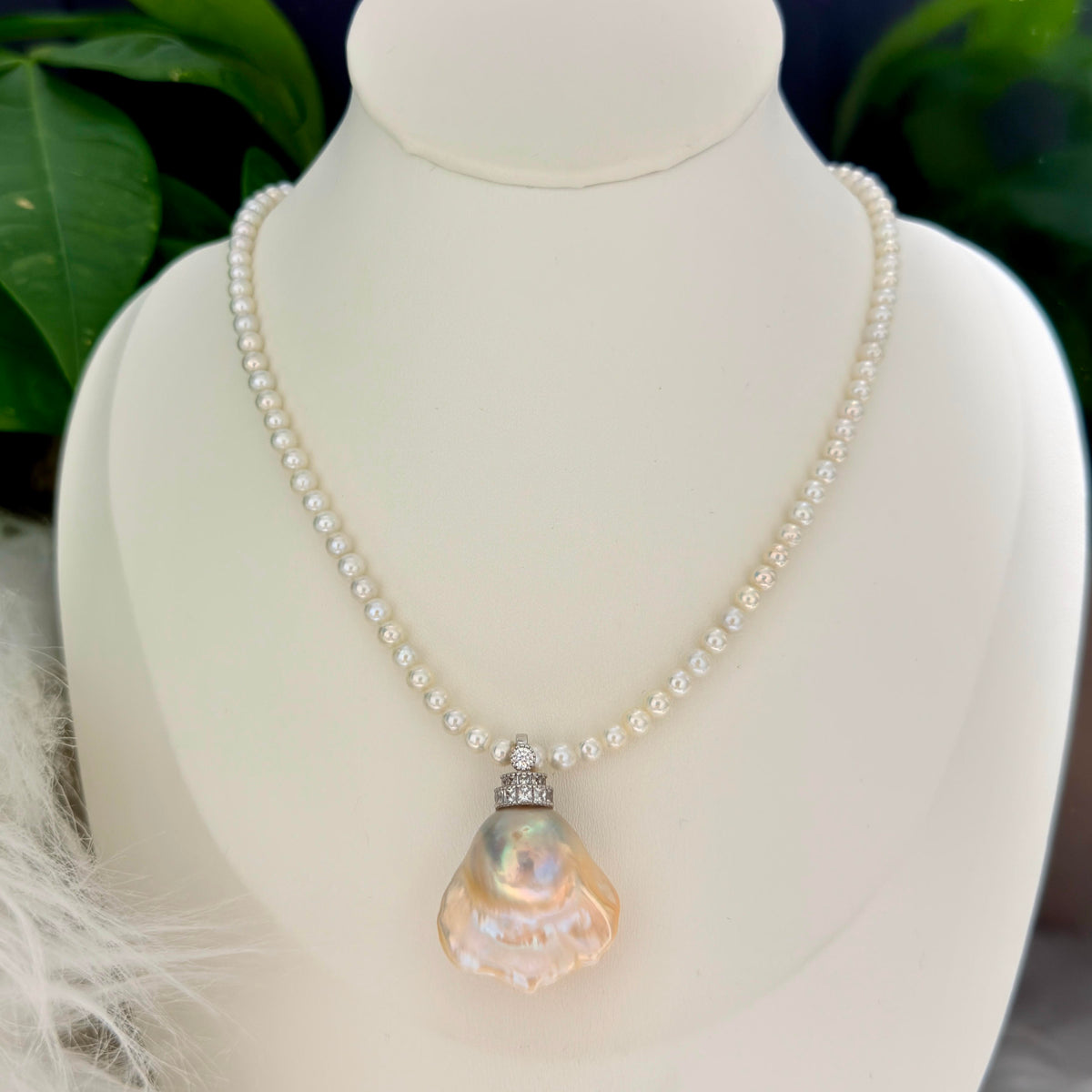 Organic pearl shape shown in golden-blue baroque freshwater pearl pendant with light golden halo and universal sterling silver bail.
