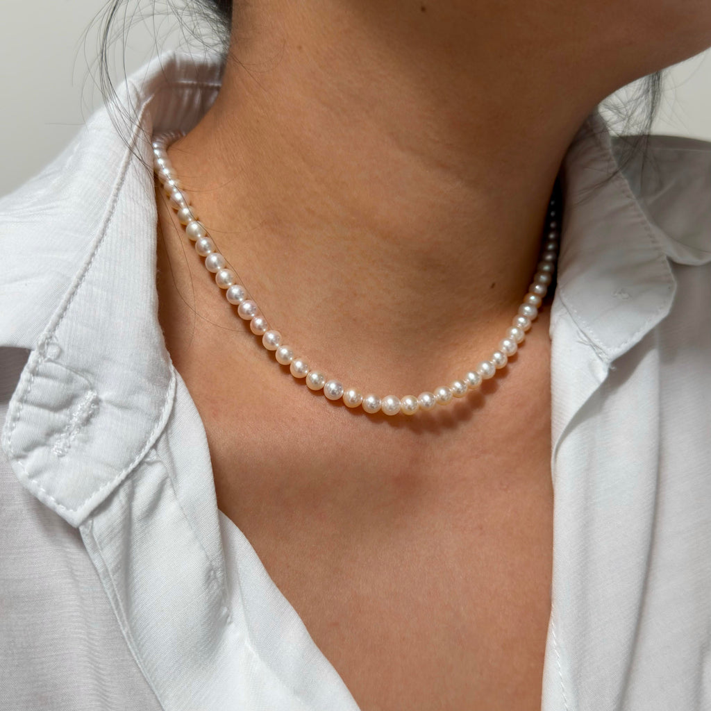 Full strand view of 5–6 mm mixed white and soft golden tones freshwater pearl necklace, 41 cm long.