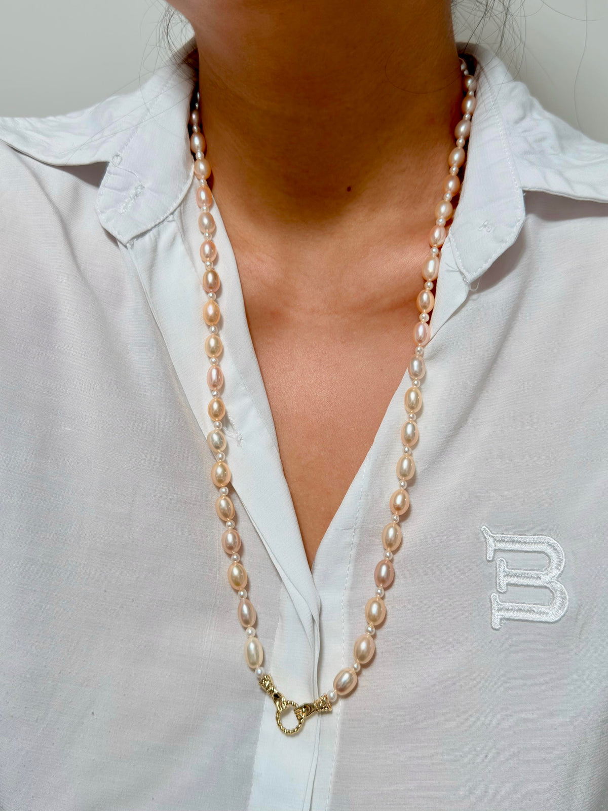Elegant long pearl necklace styled as a statement piece.