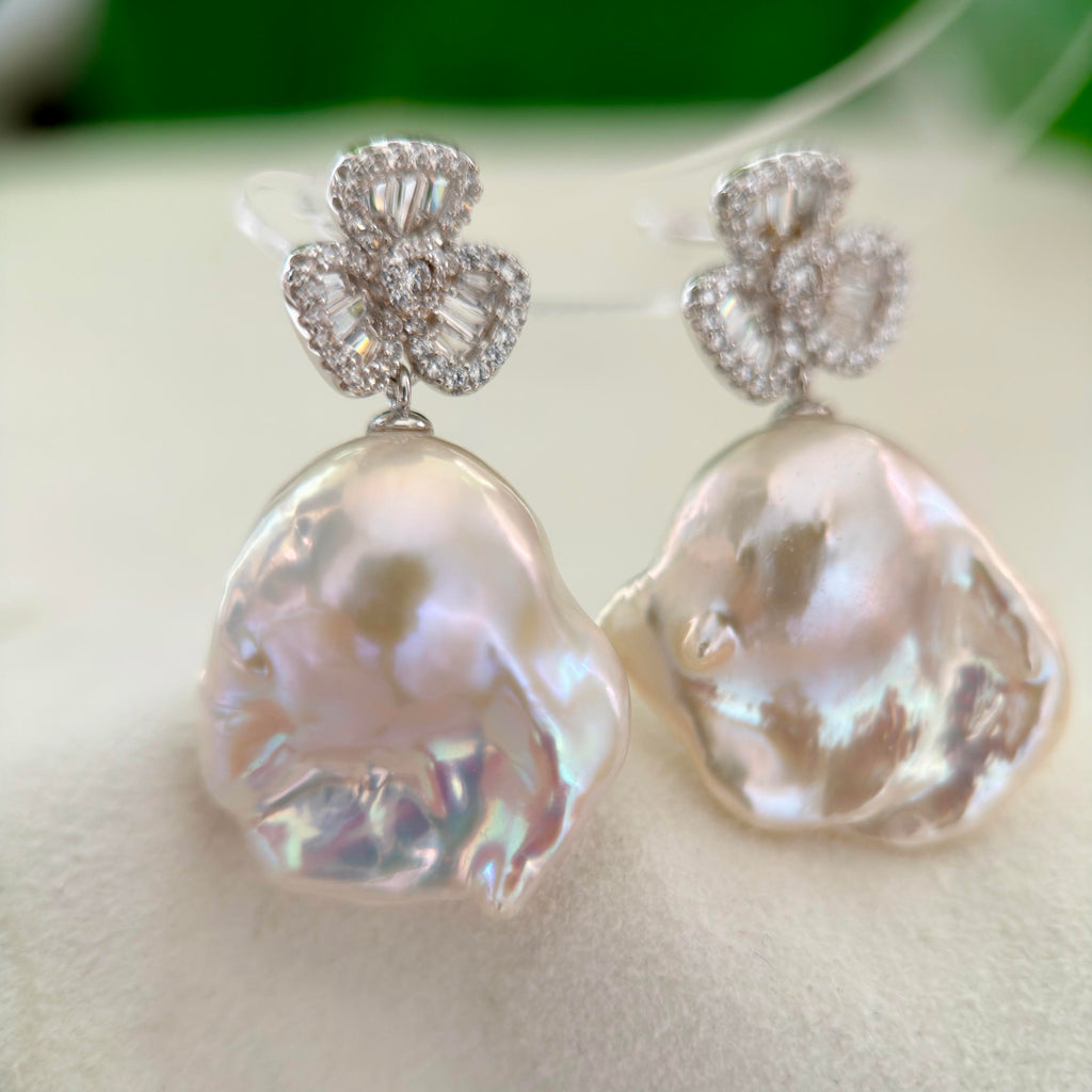 Blue and pink halo pearl earrings with a symbolic lucky charm design.
