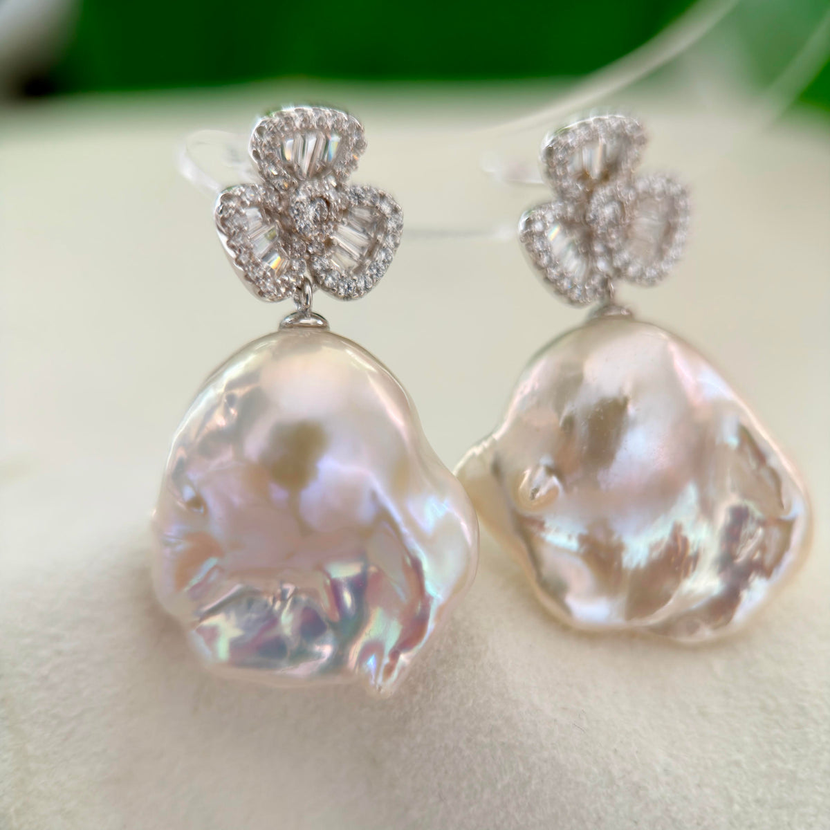 Blue and pink halo pearl earrings with a symbolic lucky charm design.
